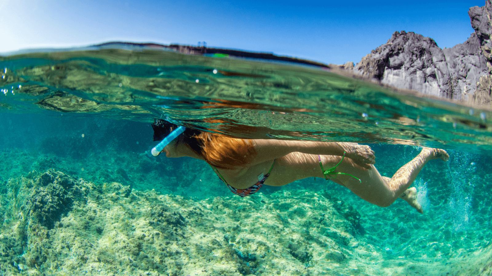 Una joven practica snorkel en las costas canarias