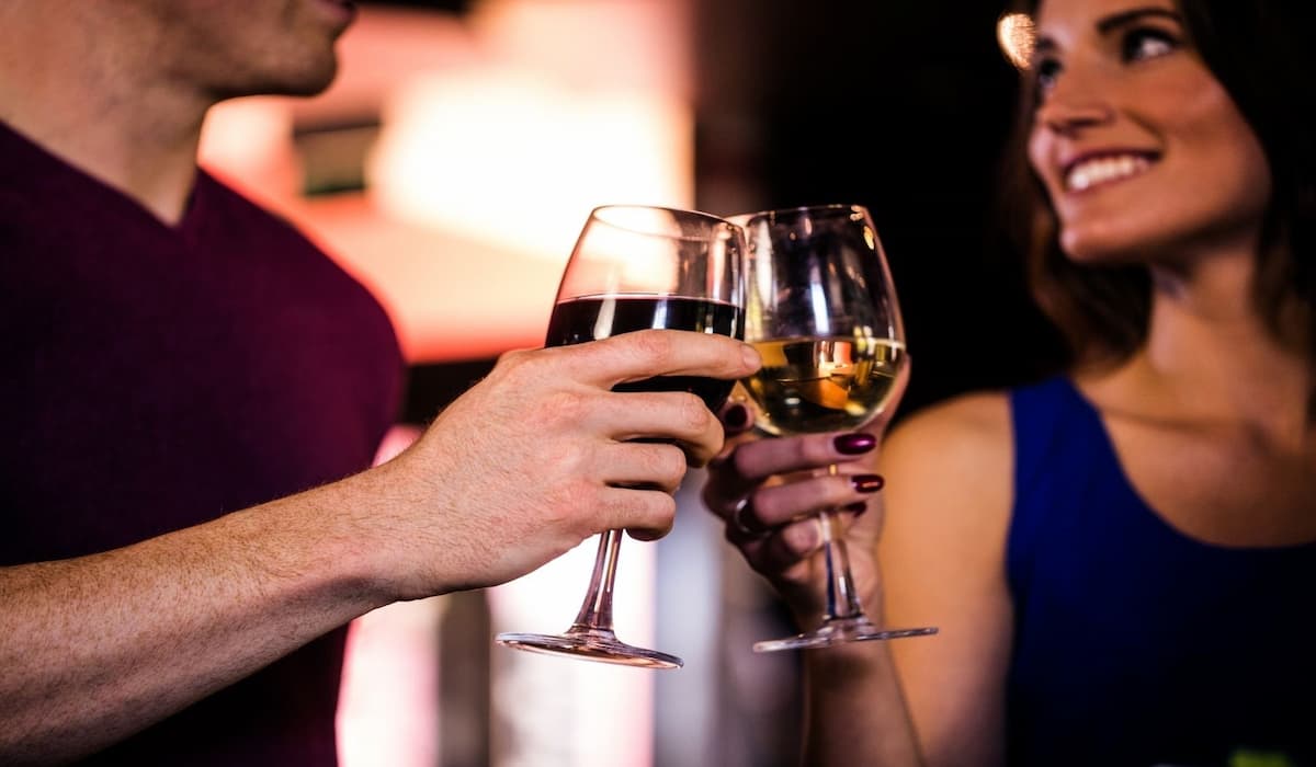 Una pareja brindando con dos copas de vino