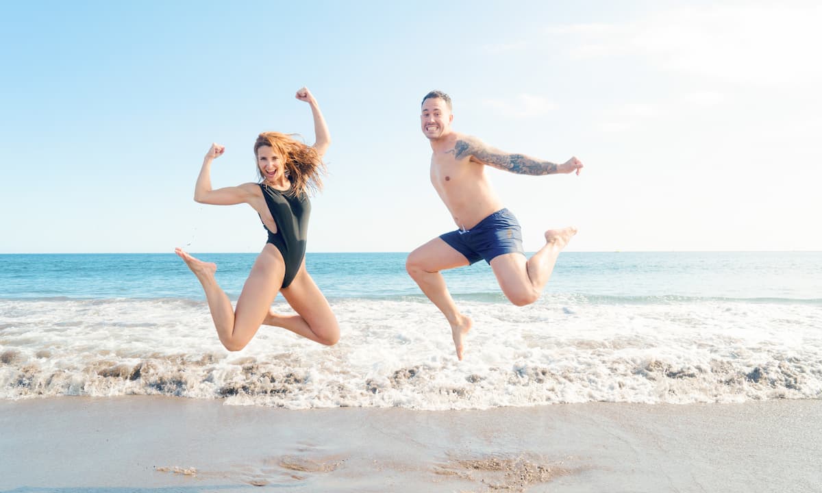 Couple jumping on the beach