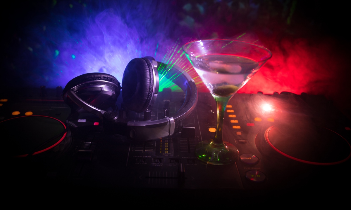 DJ-Tisch mit Kopfhörern und Martini