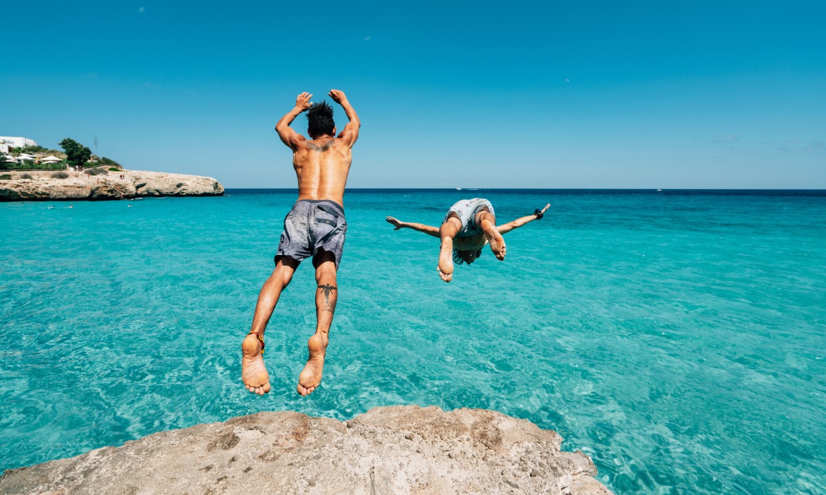 Two men diving off a rock