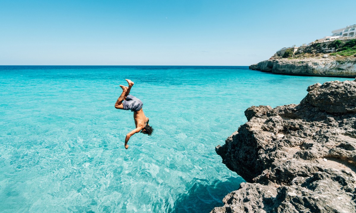 A man jumping into the sea from the West End cliffs