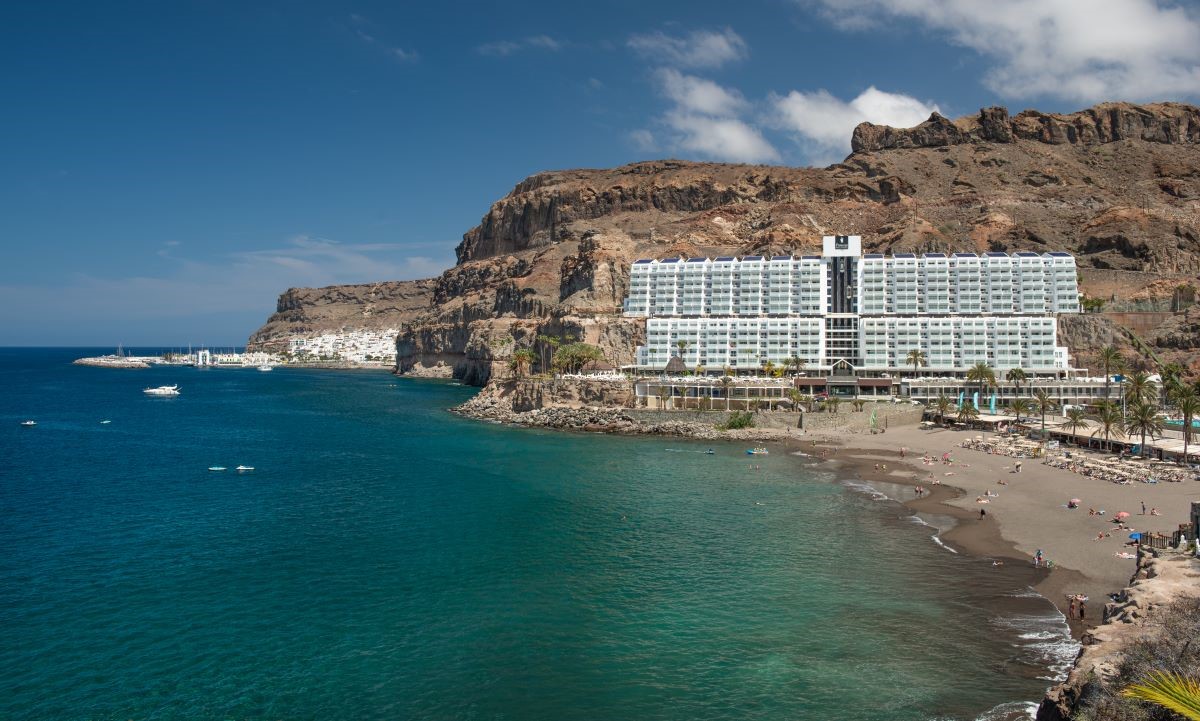 Vista frontal del Princess Taurito, hotel en primera línea de la Playa de Taurito, con Puerto de Mogán al fondo