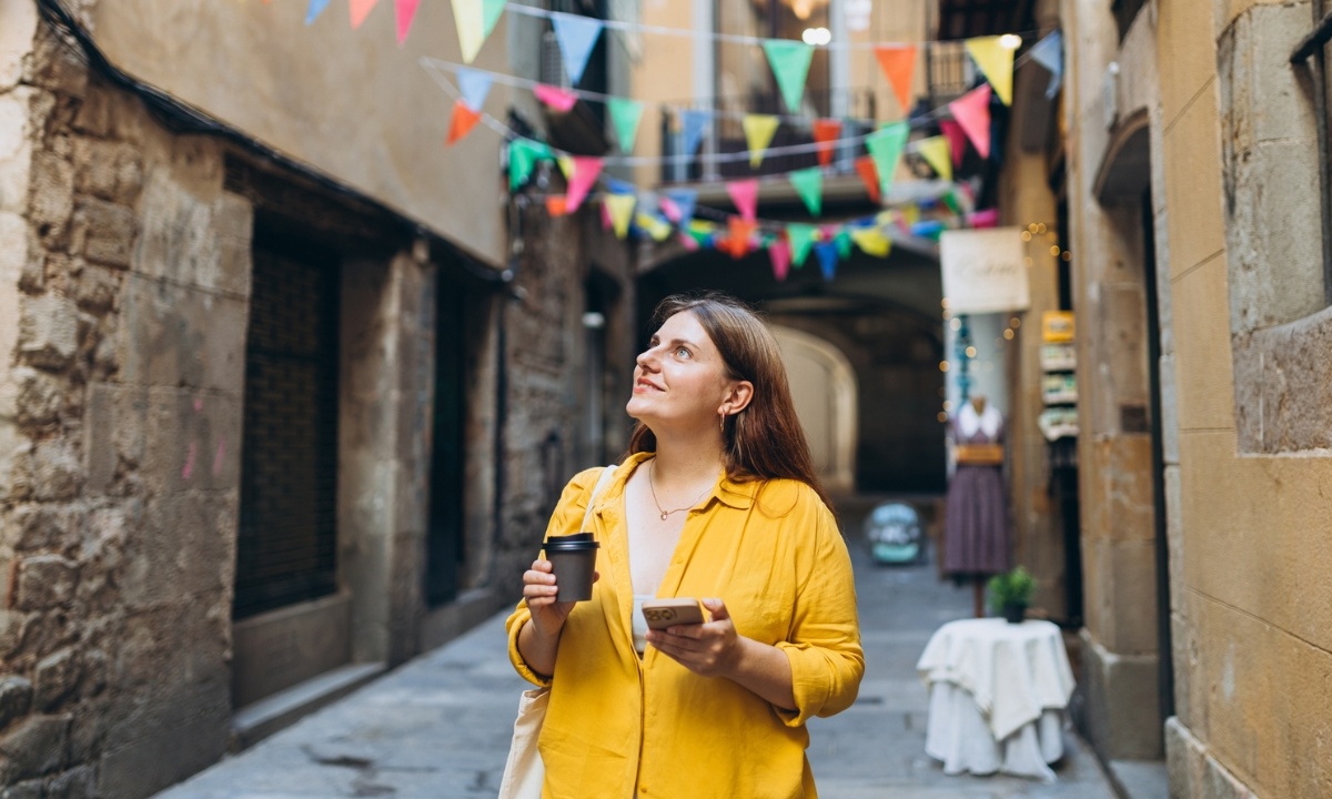 Frau geht mit bunten Bannern die Straße entlang