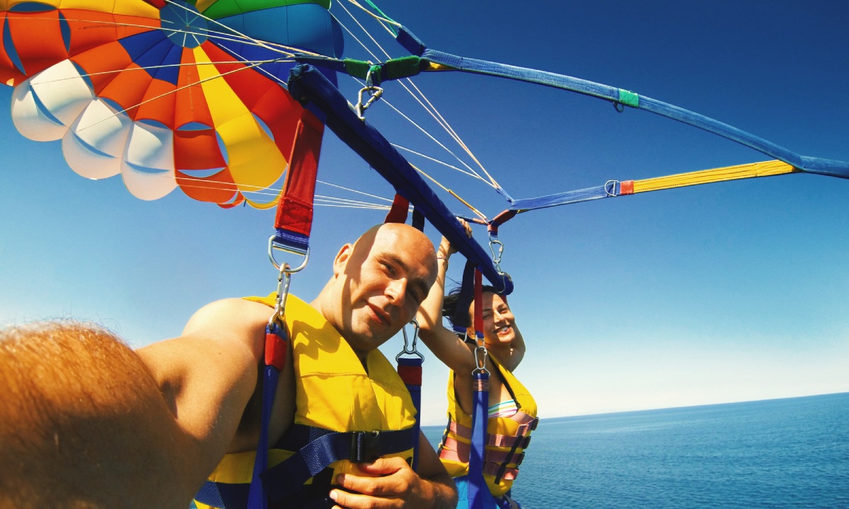 Couple parasailing over the waters of 7 Mile Beach