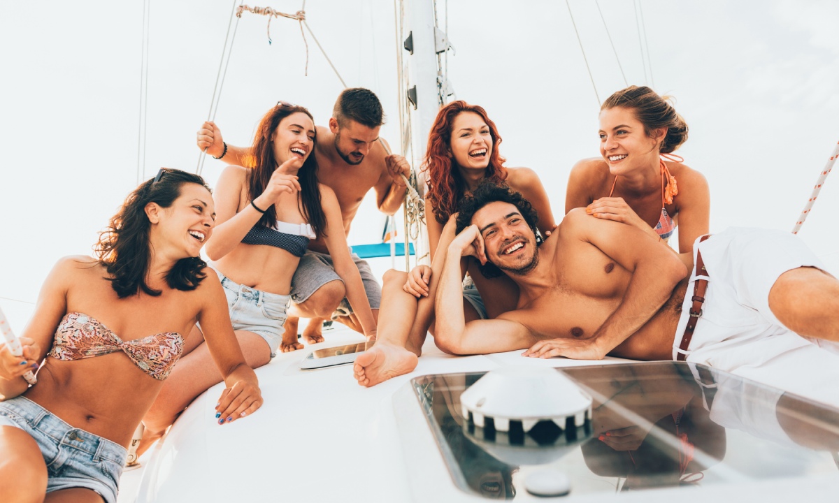 dos hombres y cuatro mujeres sonriendo en catamarán