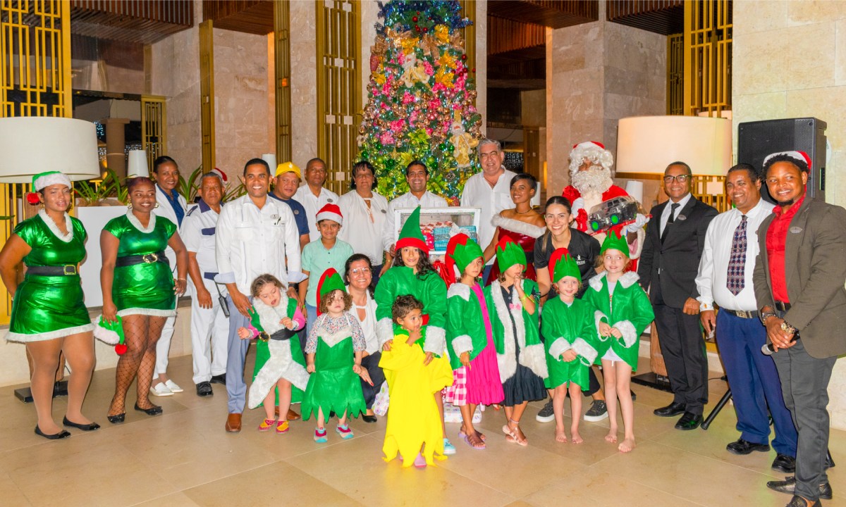 The Princess team and children dressed as elves posing by a Christmas tree