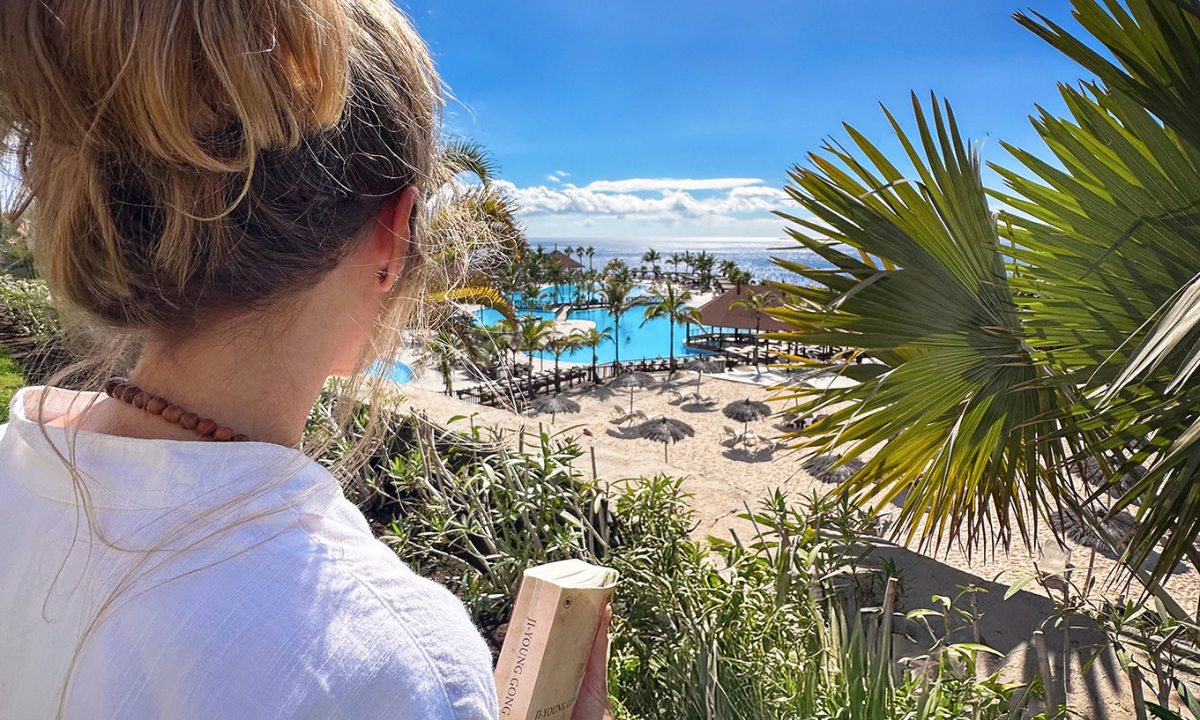 Frau blickt auf den La Palma Princess Pool und das dahinterliegende Meer