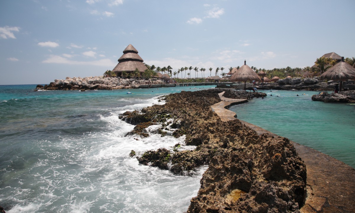 Una pareja jugando con su hija junto al mar.