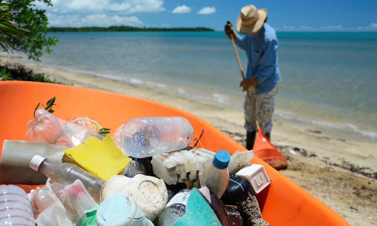 A Princess Hotels employee collecting rubbish on the beach