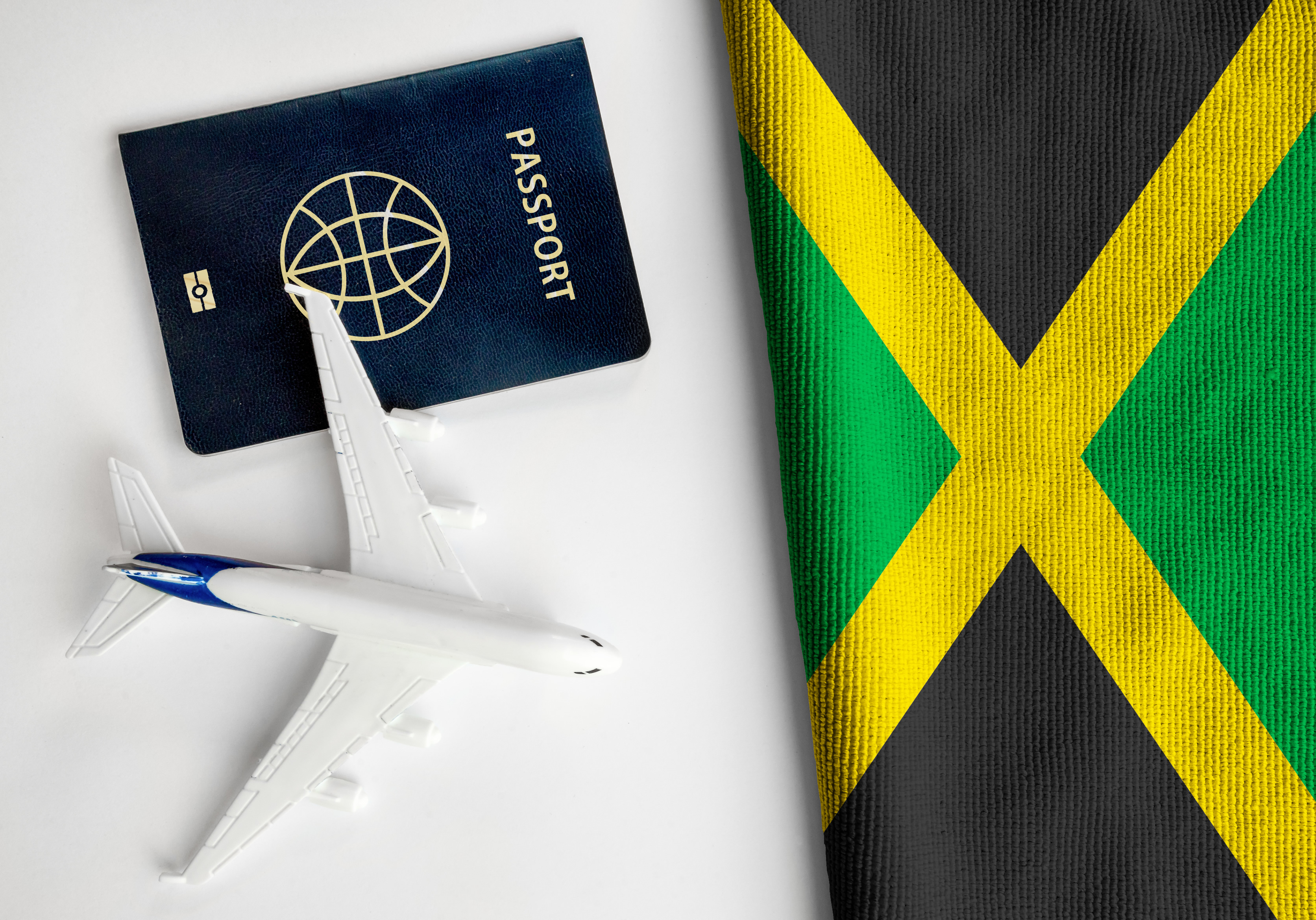 Bandera jamaicana, pasaporte y avión pequeño