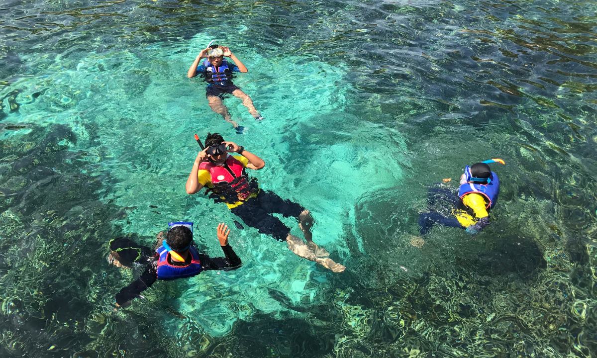 Gruppe von Personen beim Schnorcheln in kristallklarem Wasser