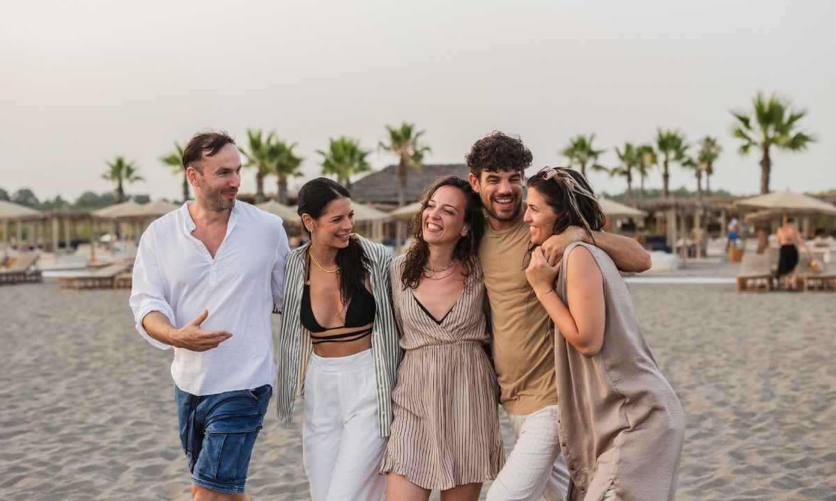 Grupo de amigos hablando en la playa
