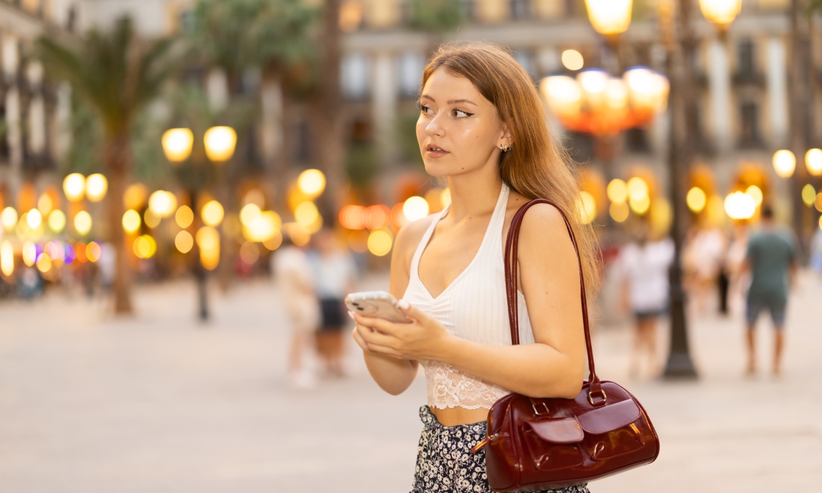 Mujer con móvil paseando en Barcelona