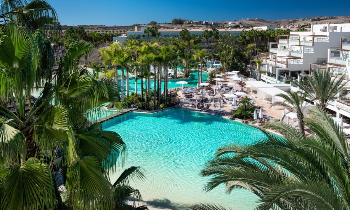 Piscina del hotel Maspalomas Tabaiba Princess rodeada de palmeras.