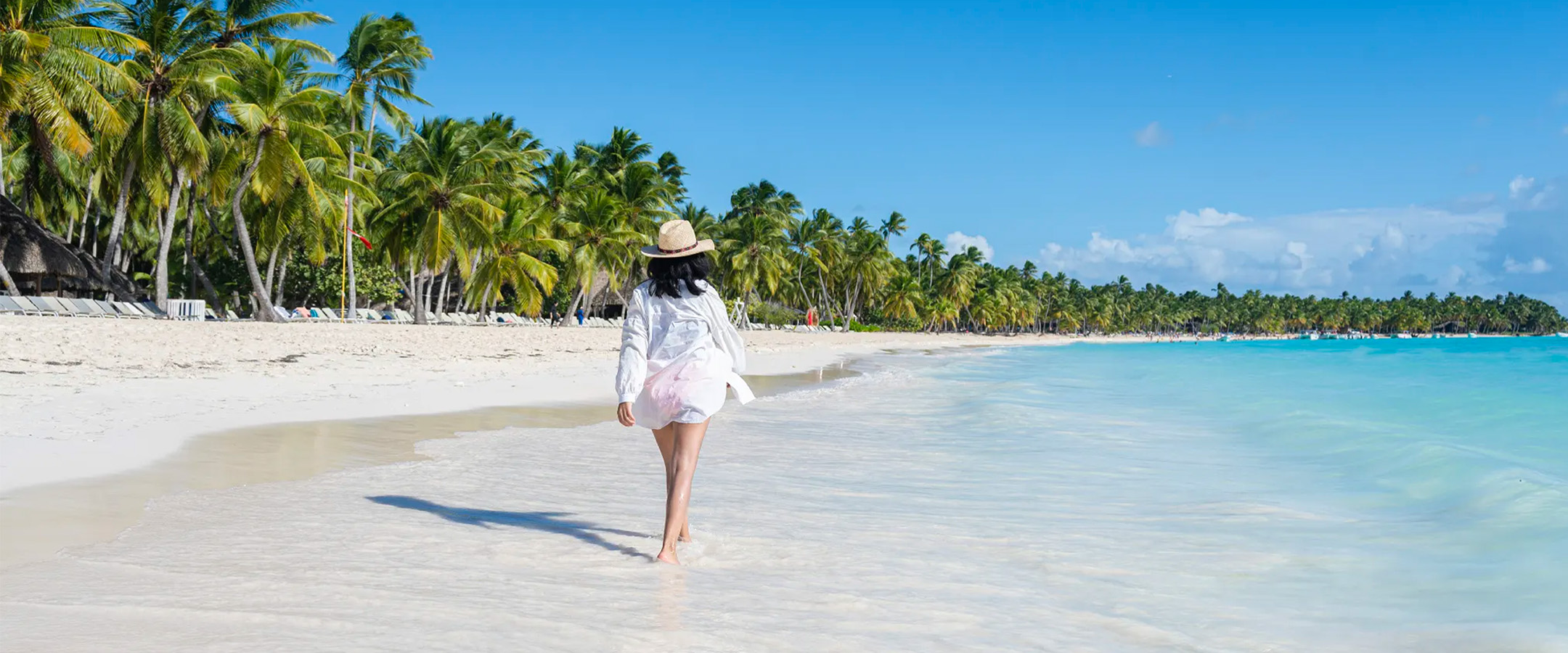 Frau spaziert an einem karibischen Strand