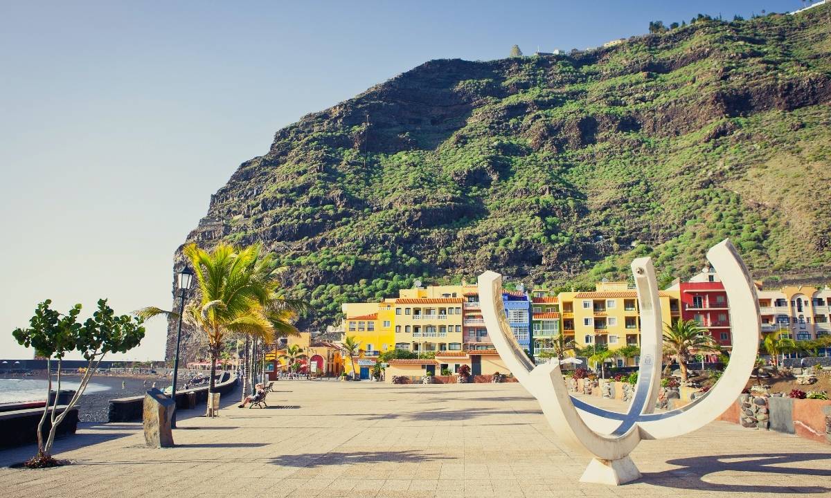 Paseo marítimo de Puerto de Tazacorte con fachadas de colores y acantilado al fondo