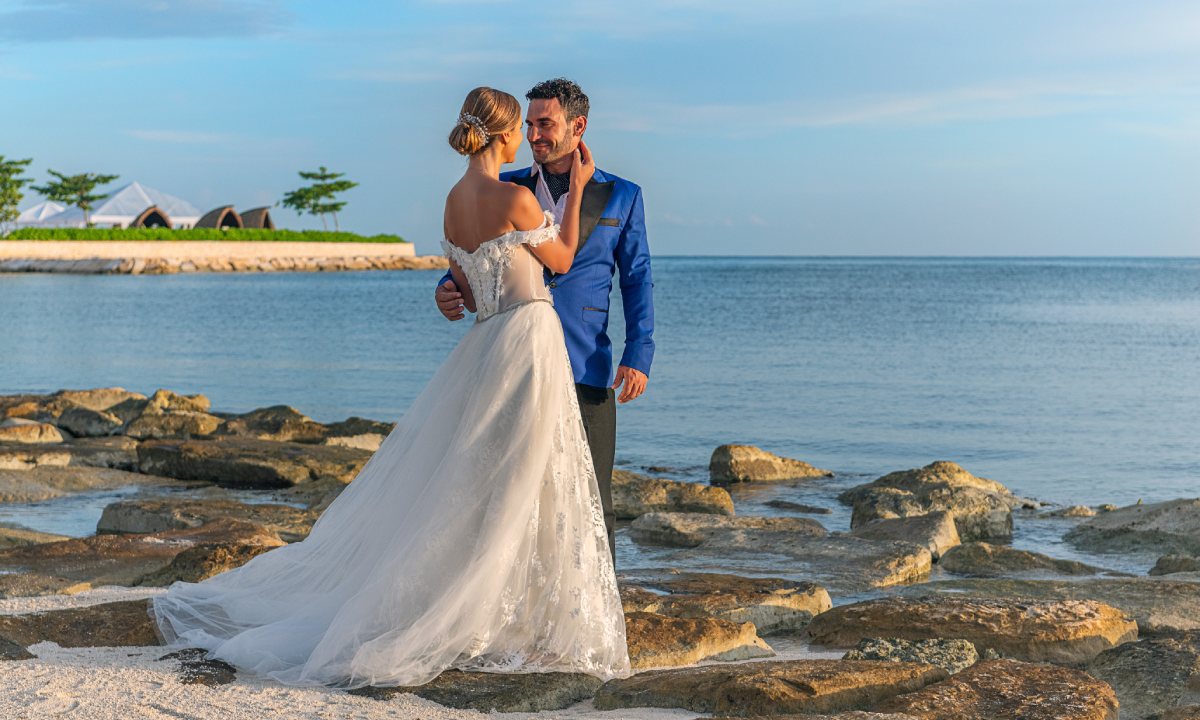 Novio y novia sobre rocas junto al mar