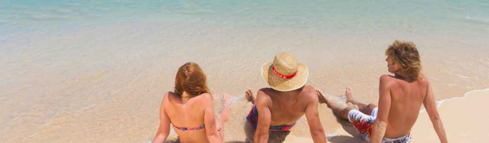 Familia disfrutando en la orilla de una playa de agua turquesa