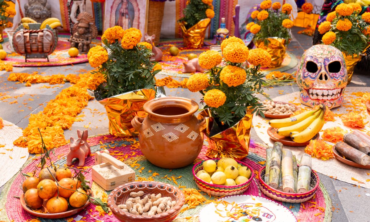 ofrenda de Día de los Muertos con comida y flores