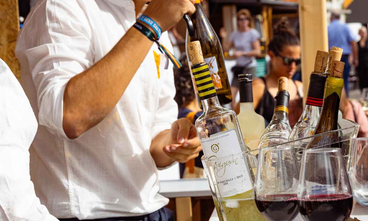 Botellas y copas de vino canario servidas en una cubeta de hielo.