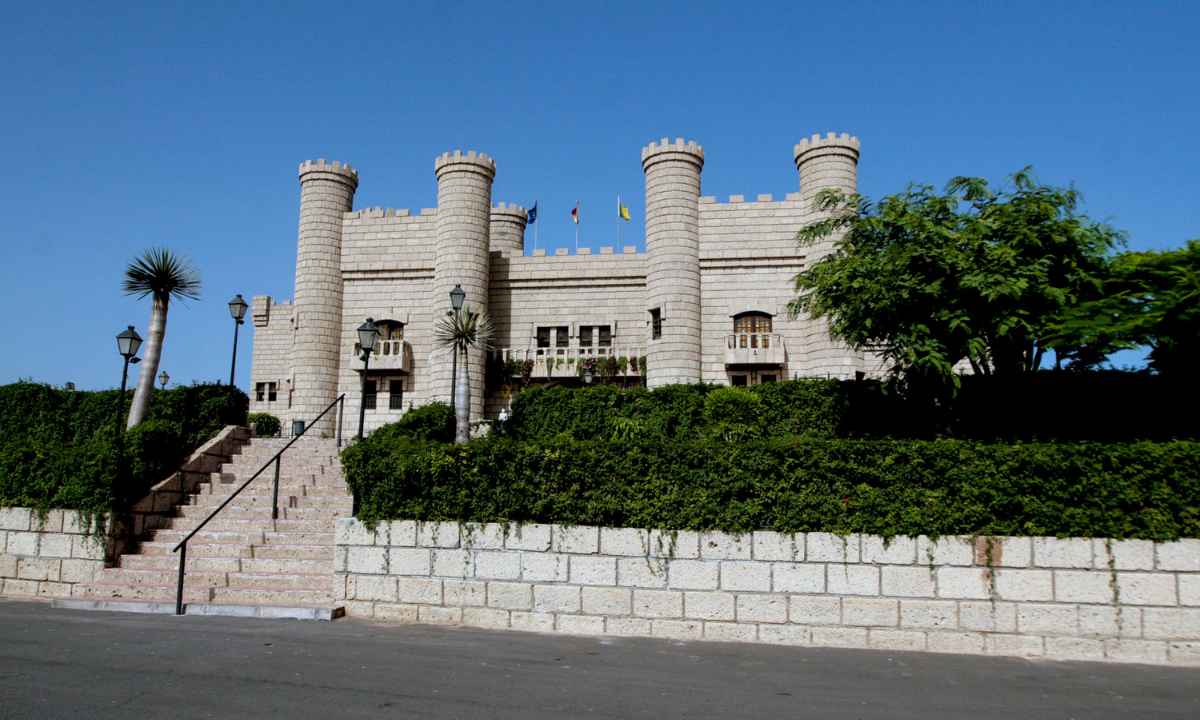 Fachada del Castillo de San Miguel con sus torres medievales de piedra y jardines en la entrada.